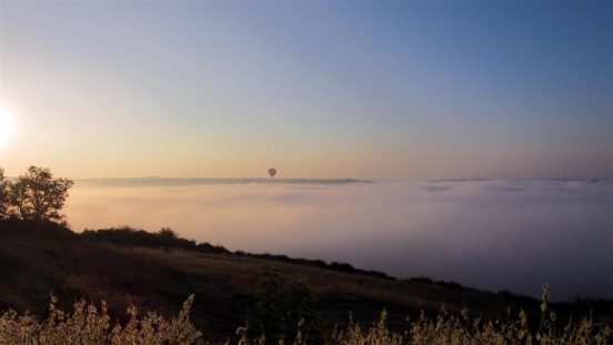 Lever de montgolfières au-dessus des brumes